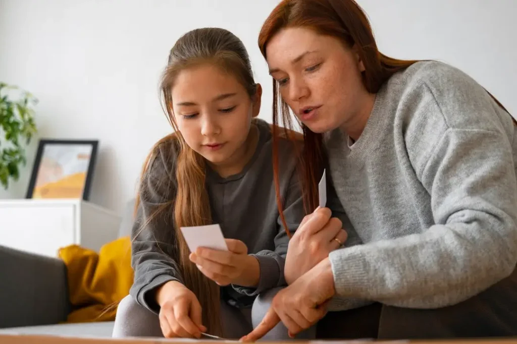 Parent and child reviewing papers together at home, focused on organizing important documents and discussing details.