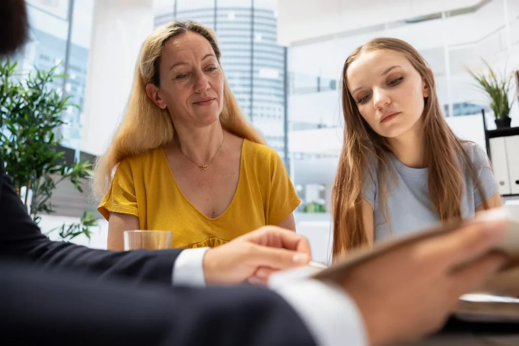 Child support attorney reviewing documents with mother and teenage daughter