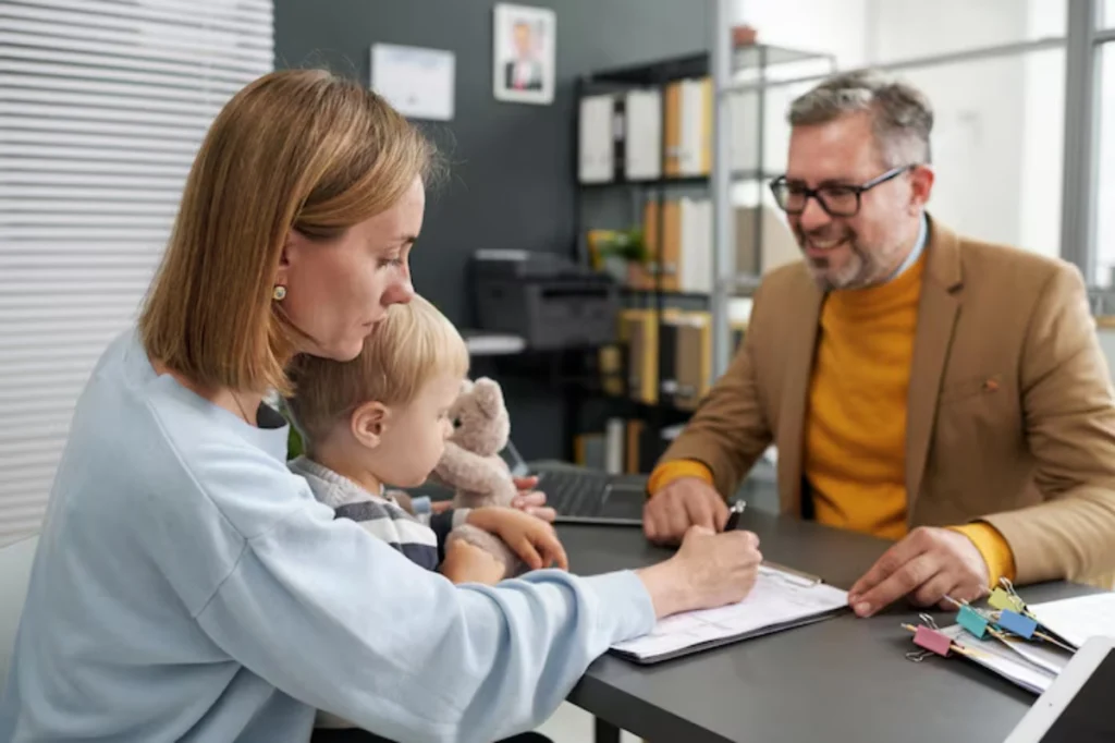 Child support attorney reviewing documents with mother and toddler in office