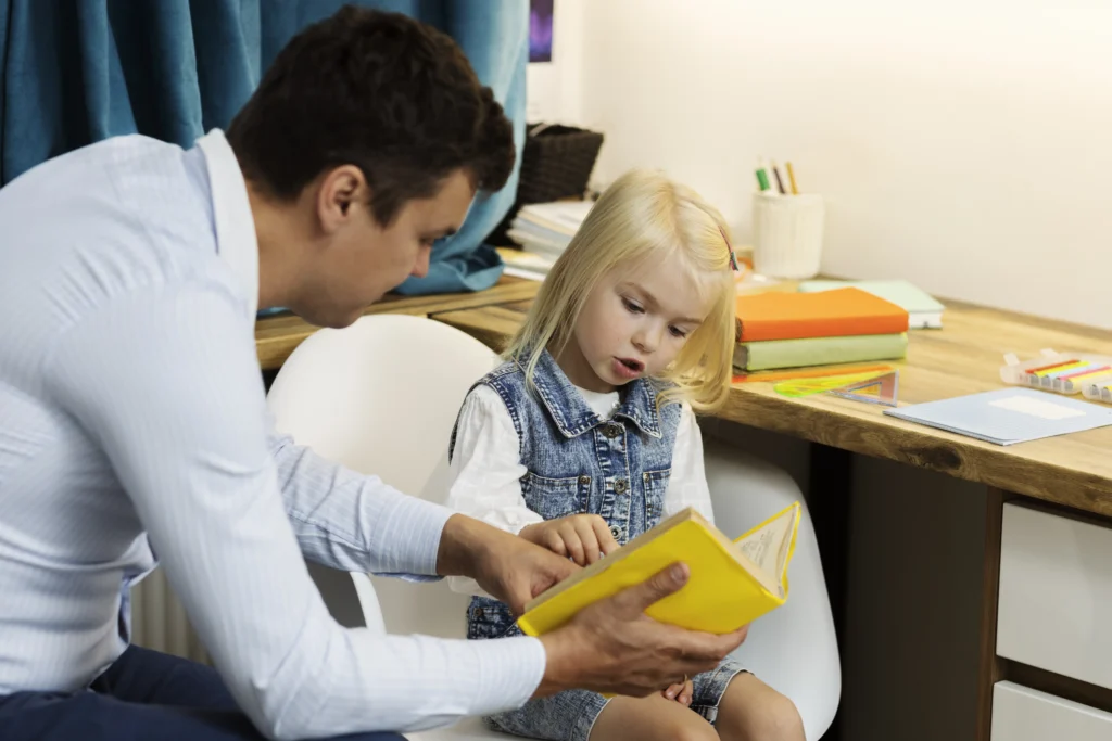 Father helping daughter read at home in child support context