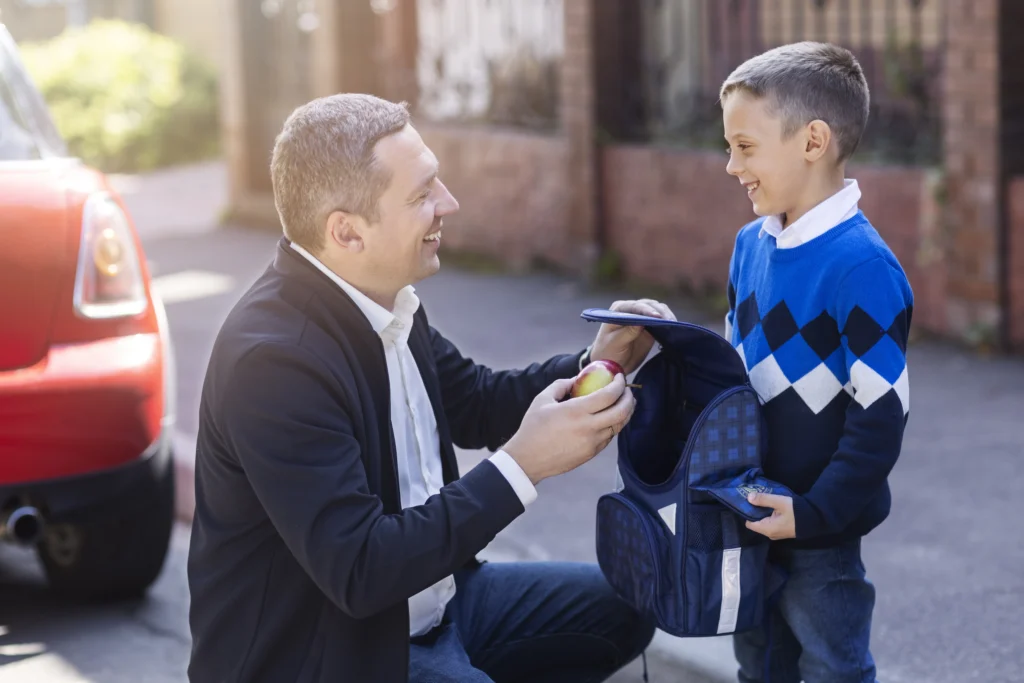 Father helping son prepare for school in child support co-parenting context