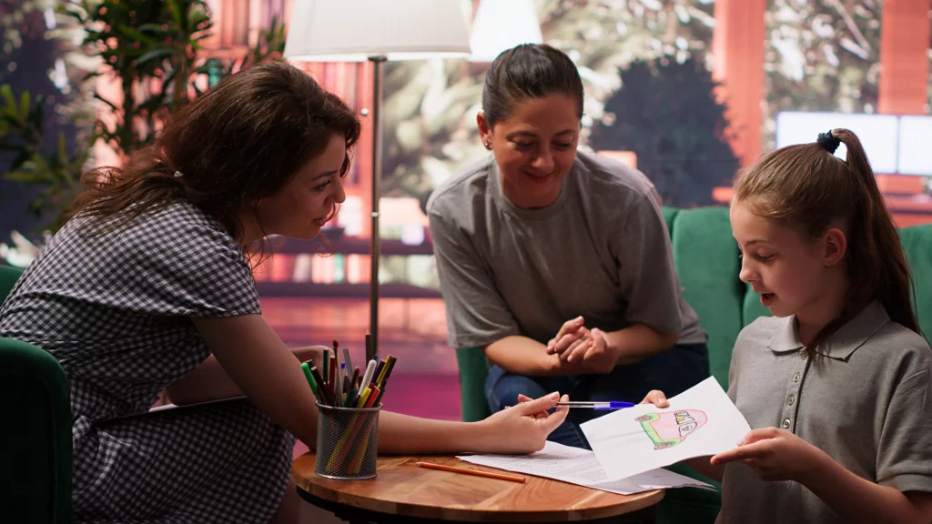 Women reviewing child’s drawing during child support co-parenting meeting