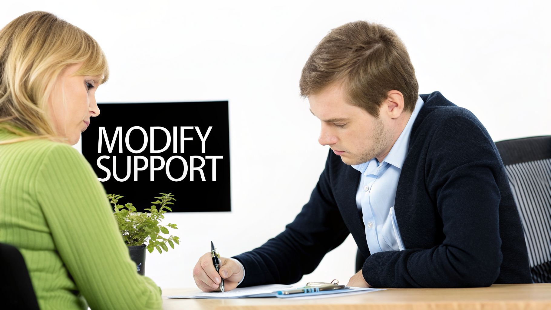A man and woman review documents at a table with 'MODIFY SUPPORT' on a screen.