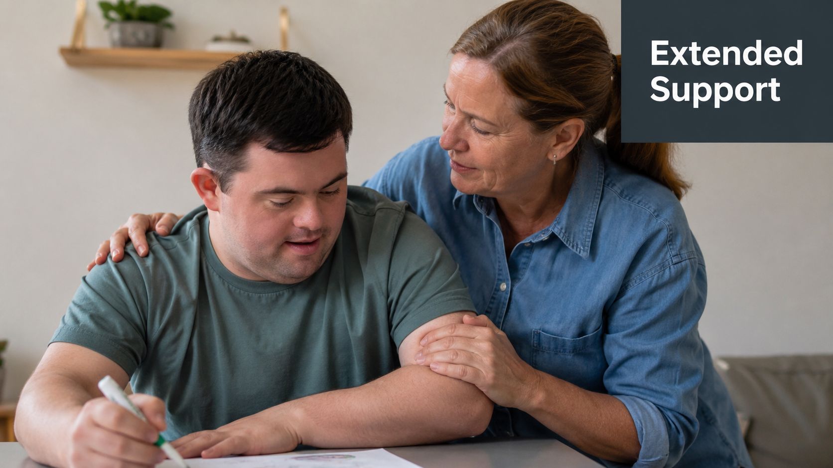 An adult caregiver provides supportive guidance to a young man with Down syndrome while he writes.